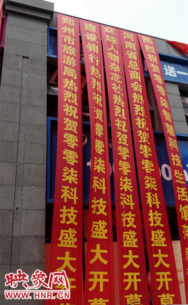路邊一棟樓上懸掛著二三十條紅色條幅，全部是祝賀一家公司開業(yè)的。