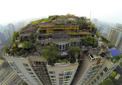 　　昨日，身穿橘黃色馬甲的工作人員在人濟(jì)山莊樓頂拆除違章建筑。新京報(bào)記者 吳江 攝