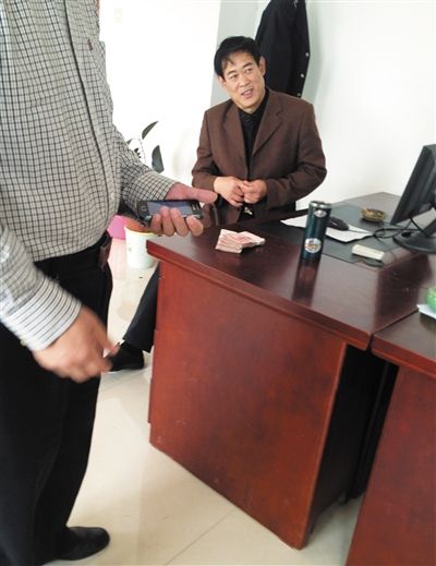 10月29日，獻縣國稅局稽查局辦公室內(nèi)，一名企業(yè)主交了兩萬元現(xiàn)金在桌上。新京報記者 孟祥超 攝