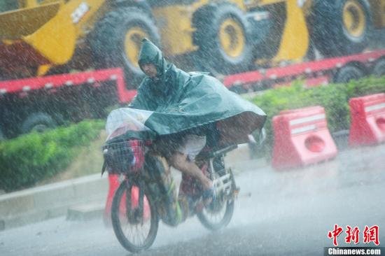 圖為南寧市民冒雨出行。中新社發(fā) 馮抒敏 攝