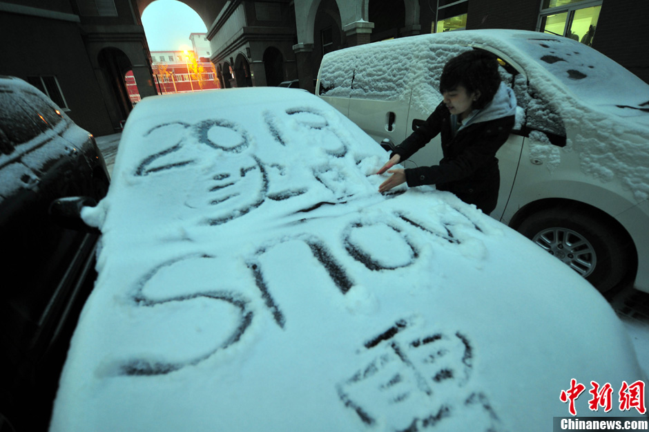 11月18日，行人在車輛的積雪上涂鴉。