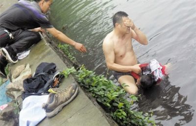 網(wǎng)友貼出民警張光聰一出河水就睜不開眼，用手抹去臉上臟水的照片。