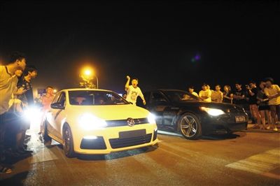 8月24日晚，東壩中街飆車(chē)現(xiàn)場(chǎng)，兩輛車(chē)并排等待出發(fā)指令，旁邊許多愛(ài)好者前來(lái)觀看比賽。新京報(bào)記者