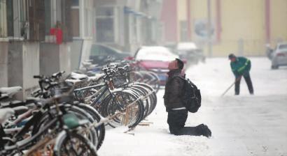 小伙子跪在樓前，一直抬頭看著樓上。 孫立國/攝