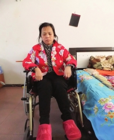 陳慶霞坐在輪椅上。她現(xiàn)在下身癱瘓，疾病纏身，生活不能自理。