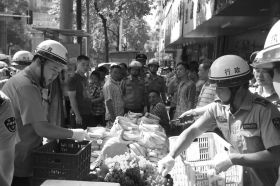 7月11日，瀏陽市北正中路，執(zhí)法人員暫扣張海的水果。這是瀏陽市城管局拍攝的執(zhí)法現(xiàn)場圖。