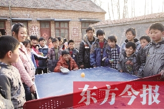 坐著輪椅的小宗成和同學(xué)們一塊打乒乓球，這是他感到最快樂的事