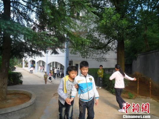4年來(lái)，13歲的余興泉（左一）每天都攙扶著腿腳不便的同學(xué)左臣進(jìn)出教室、食堂和廁所。 李俊杰 攝