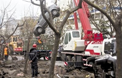 輸油管道爆炸后，搶修人員將被炸毀的車輛運(yùn)出現(xiàn)場(chǎng)。