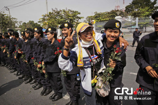 2013年12月03日,曼谷總理府與曼谷警署允許反政府示威民眾進(jìn)入,雙方進(jìn)入暫時“停戰(zhàn)”狀態(tài)迎接泰王生日。曼谷警察總署,女警們手持鮮花送給反政府示威民眾。圖片來源:Manish Swarup/東方IC