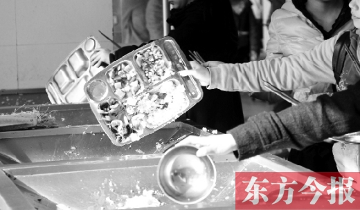 11月27日，河南中醫(yī)學(xué)院餐廳，一名同學(xué)將餐盤內(nèi)沒(méi)吃完的食物倒入餐具回收車內(nèi)