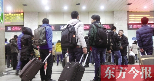 鄭州火車(chē)站東廣場(chǎng)售票大廳，幾名學(xué)生在售票窗口前躊躇