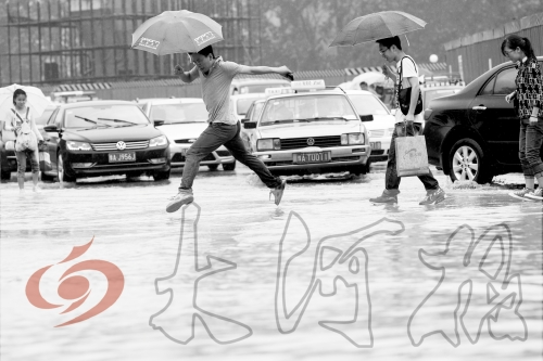 鄭州經(jīng)三路與北環(huán)交叉口處，積水較深，行人們不得不“練輕功”。 記者 白周峰 攝影