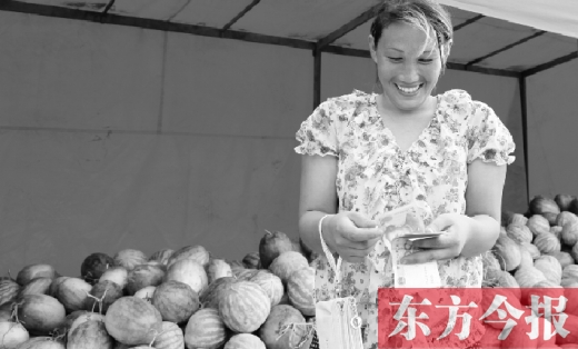 昨日，開封瓜農(nóng)史瑩瑩幸福地數(shù)著賣瓜錢 東方今報記者 沈翔 攝