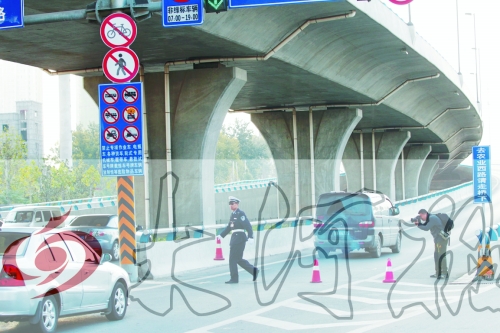 交警在東風(fēng)路從北向南上橋口處擺上反光錐，間歇放行