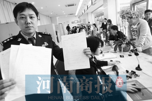 　民警左手拿的是新申請表，右手拿的是三份老申請表 王春勝/攝