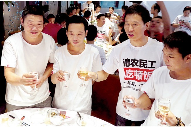 活動發(fā)起人張楠（右二）給農民工敬酒。