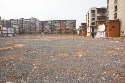 為降塵，旮旯王村拆遷后裸露的地面上鋪了一層石子。
