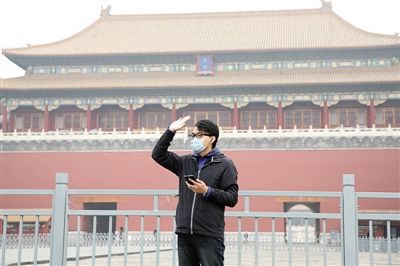 11月1日，北京大部分地區(qū)重度污染，一名游客戴著口罩在午門前揮手跟朋友打招呼。 實(shí)習(xí)生 王飛 攝