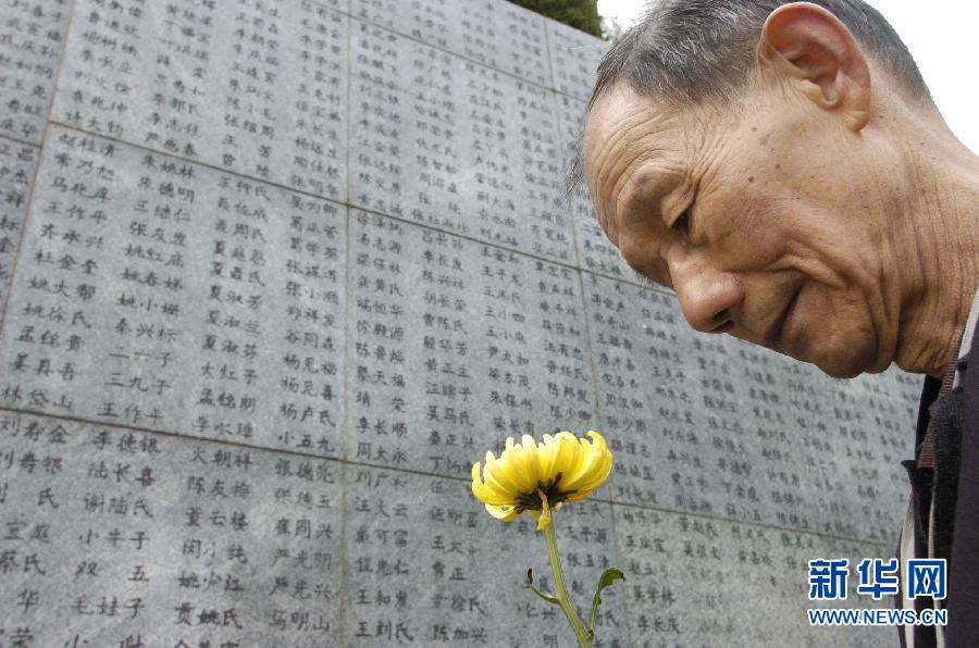 2006年4月5日，74歲的南京大屠殺幸存者佘子清手捧鮮花，祭奠被日軍殺害的母親。