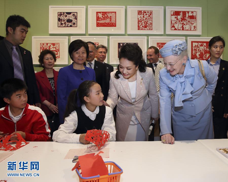 這是彭麗媛和瑪格麗特二世與根據(jù)安徒生童話中人物和情節(jié)制作剪紙的孩子交談。