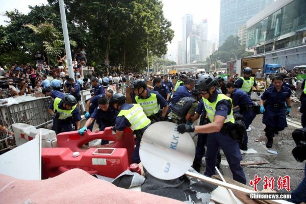 10月14日，警方清除金鐘道障礙物。大批警員在金鐘道現(xiàn)場清拆障礙物。部分警員戴上頭盔將障礙物移走。
