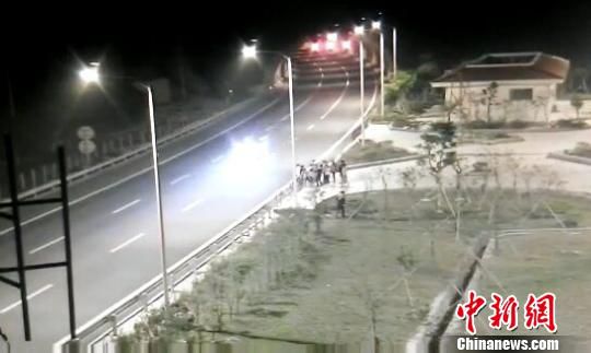 看到車輛經(jīng)過，孩子們便急忙跑到一旁的花圃上?！【焦﹫D　攝