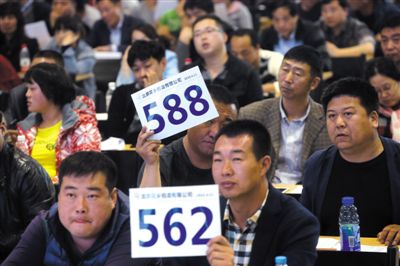昨日，拍賣現(xiàn)場競拍者舉牌競拍。新京報記者
