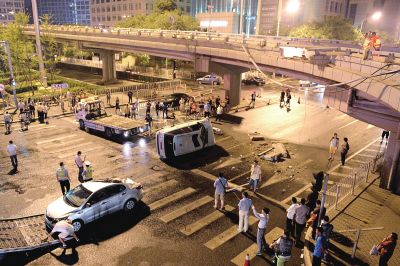 路虎沖下國(guó)貿(mào)橋砸中一輛起亞轎車，橋上厚達(dá)幾十厘米的水泥護(hù)欄被撞斷，碎石四處散落，數(shù)十群眾在現(xiàn)場(chǎng)圍觀。