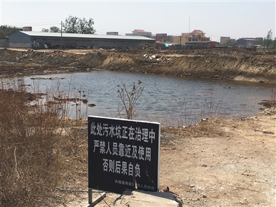 化肥廠滲坑的三分之一經(jīng)過治理，但水質(zhì)仍然呈黃褐色。