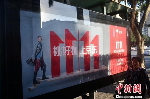 資料圖：11月1日，福州民眾從雙十一廣告牌前經(jīng)過。中新社記者 呂明 攝