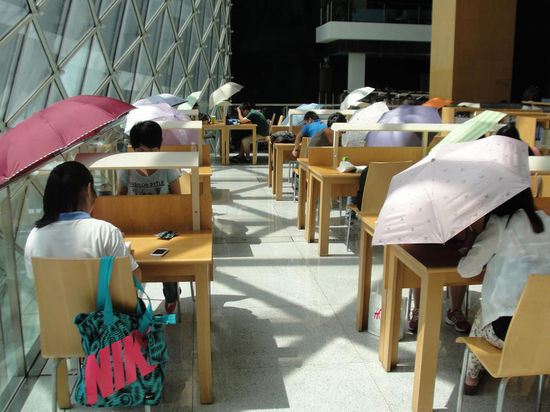 2015年8月2日，深圳圖書館，“太陽曬進(jìn)來很熱的，我們都要撐著傘讀書?！? complete=