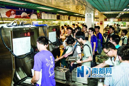 昨日，華南理工大學(xué)一食堂內(nèi)，學(xué)生們正在使用新安裝的自動打飯機(jī)打飯。中新社發(fā)