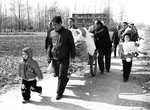 姐（左一）弟（右一護(hù)士懷中男嬰）返鄉(xiāng)，愛心捐贈滿滿一架子車。