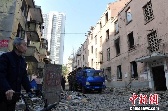 一位花甲老人站在即將拆除的樓房旁，默默地與“蘇聯(lián)樓”告別。　翟羽佳　攝